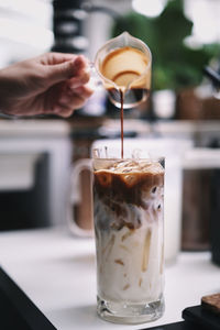 Midsection of woman holding coffee on table