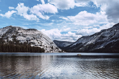 Scenic view of lake by snowcapped mountains against sky