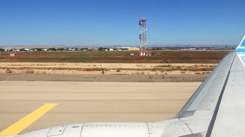 Airplane on landscape against clear blue sky