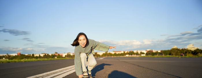 Rear view of woman walking on road against sky