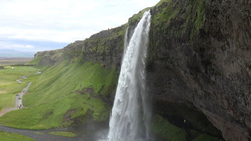 Scenic view of waterfall against sky