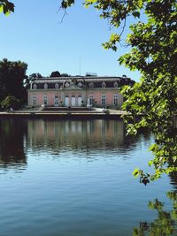 Buildings by lake against sky