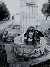 Woman standing by tree trunk