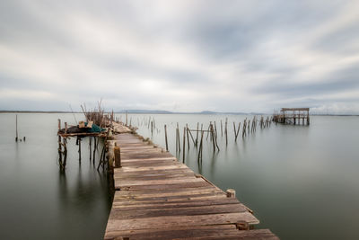 Wooden pier in sea against sky