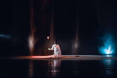 Man and woman dancing in water at night