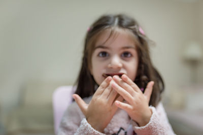 Portrait of cute girl eating chocolate at home