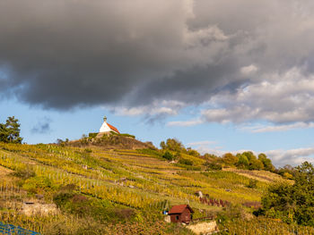 Scenic view of landscape against chapel on hilltop and sky