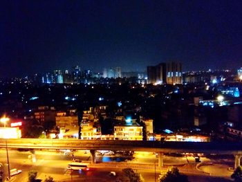 Illuminated buildings in city against sky at night