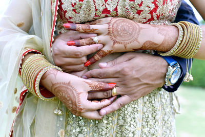 Midsection of couple holding hands