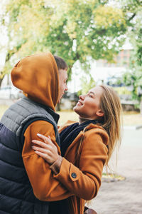 Couple embracing on footpath in city