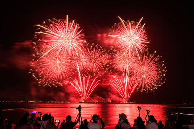 People watching fireworks at night