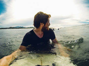 Rear view of man on beach against sky