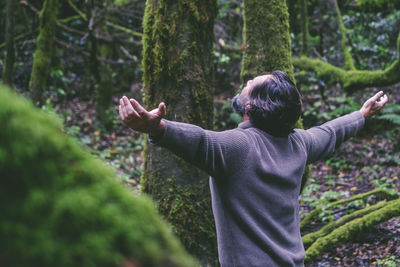 Rear view of man standing in forest