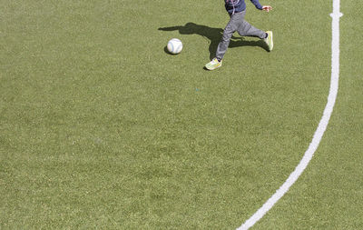 Low section of man playing soccer on field