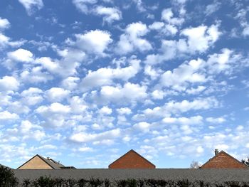 Low angle view of buildings against cloudy sky