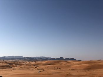 Scenic view of desert against clear blue sky