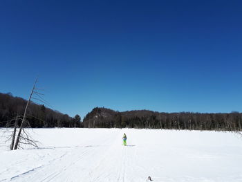 Scenic view of snowy field against clear blue sky