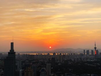 View of buildings against cloudy sky during sunset