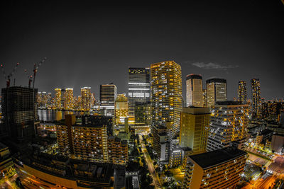 Illuminated buildings in city against sky at night