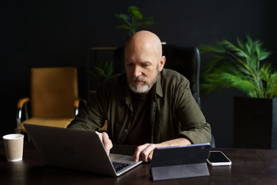 Portrait of man using laptop at home