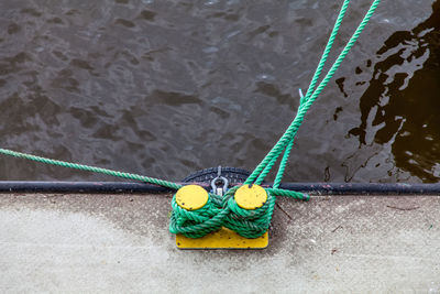 High angle view of rope tied to moored boat at harbor