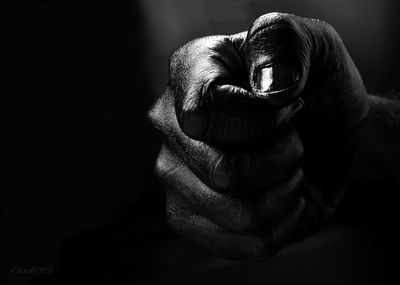 Close-up of human hand against black background