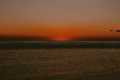 Scenic view of sea against orange sky