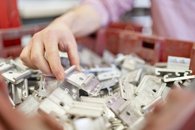 Close-up of man's hand in box with workpieces