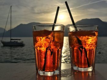 Close-up of drink on table at sunset