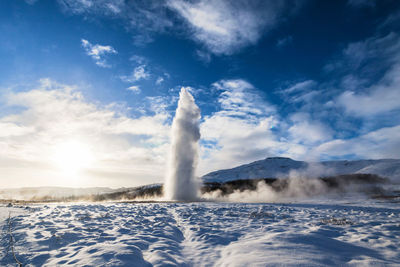 View of waterfall against cloudy sky