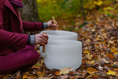 Midsection of man playing singing bowl outdoors