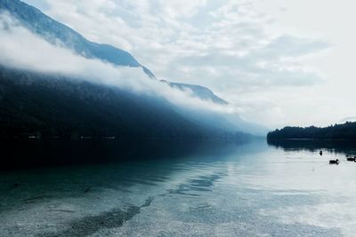 Scenic view of lake by mountains against sky