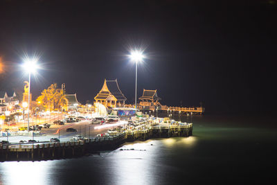 Illuminated harbor against sky at night