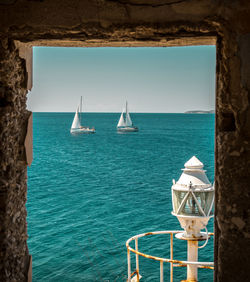 Sailboats sailing in sea against sky