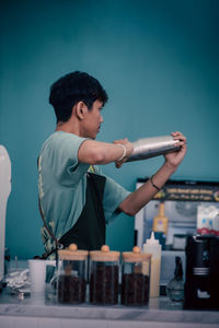 Side view of young man drinking water