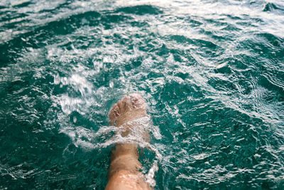 Low section of person feet in swimming pool