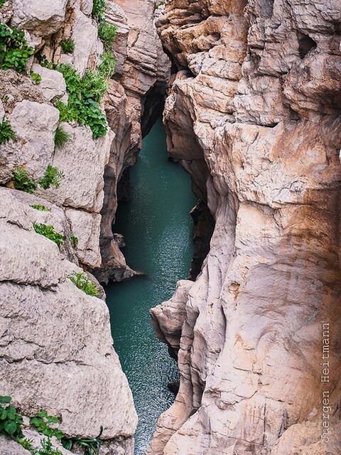 rock - object, rock formation, water, rock, nature, tranquility, textured, rough, beauty in nature, tranquil scene, stone, high angle view, outdoors, day, stone wall, geology, scenics, rocky, no people, cliff