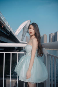 Portrait of smiling young woman standing against sky