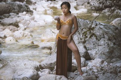 Full length of young woman standing on rock