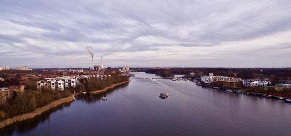 Panoramic view of river by city against sky