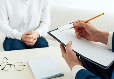 Midsection of couple holding hands on table