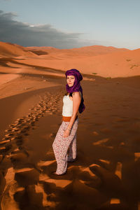 Woman standing on sand dune in desert