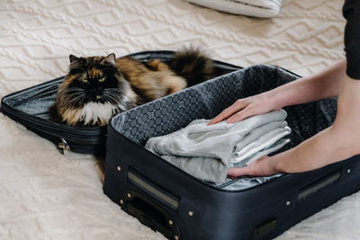 A young man puts things in a suitcase.