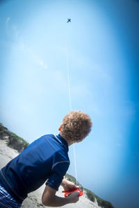 Low angle view of man paragliding against sky