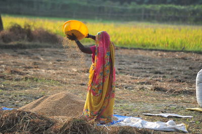 Rear view of woman in traditional clothing working at farm