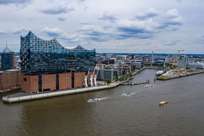 River amidst buildings in city against sky