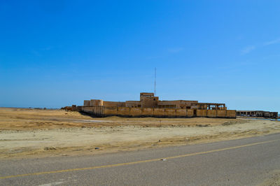 Built structure on land against clear blue sky