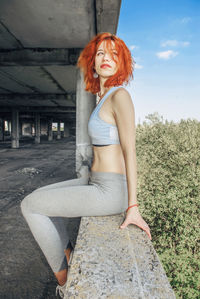 Fitness woman sitting on floor. woman taking rest after working out at fitness studio inside