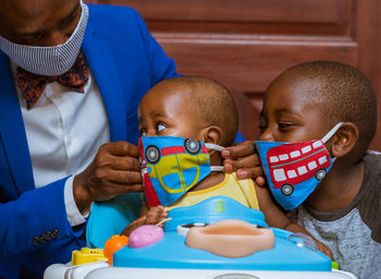 Father and sons wearing face masks