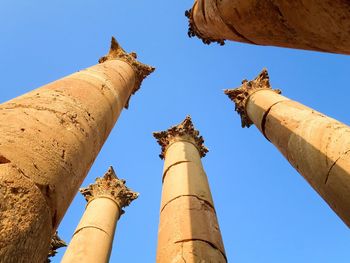 Low angle view of statues against blue sky